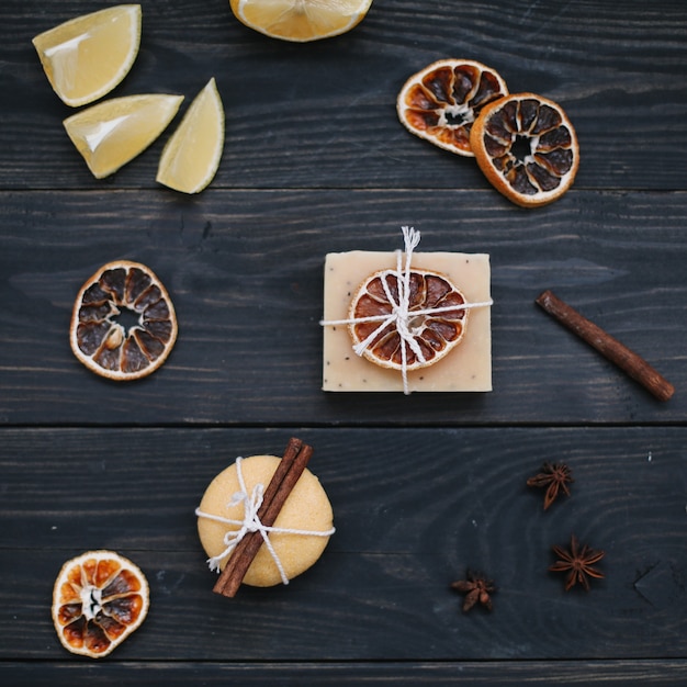 Natural handmade soap with dried slices of oranges on a dark surface