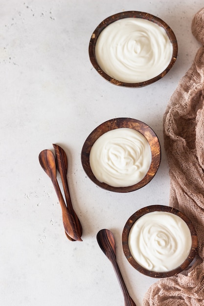 Foto yogurt naturale fatto in casa biologico in ciotole di guscio di cocco prodotto a base di latte fermentato fresco e naturale