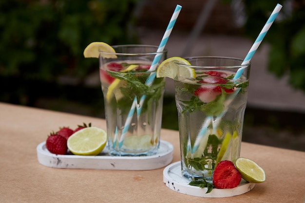 Natural homemade summer cocktails with strawberry ice lime lemons and mint Infused vitaminized detox healthy drinks Refreshing diet natural water