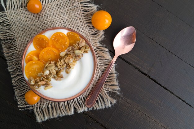 Natural homemade yogurt with ground-cherry on a wooden table.
