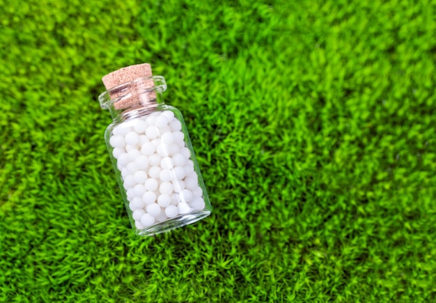 Natural homeopathic pills on a green moss