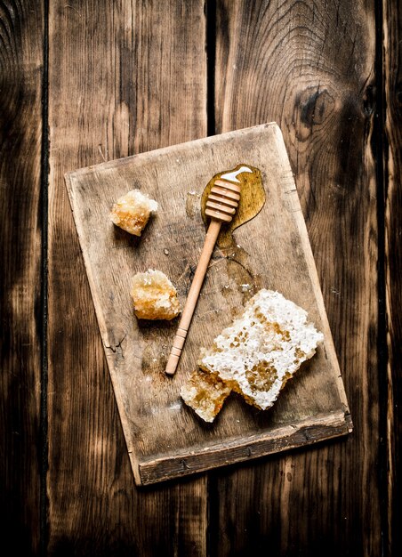 Natural honey in honeycombs with a spoon on the Board on wooden background