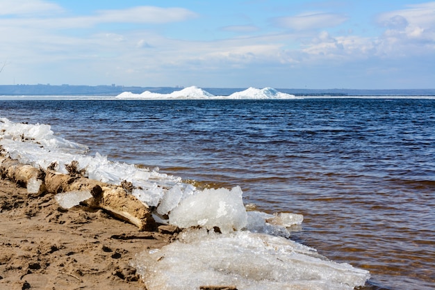 Blocchi di ghiaccio naturale che si rompono contro la riva durante il clima primaverile. artico, inverno, paesaggio primaverile. deriva del ghiaccio.