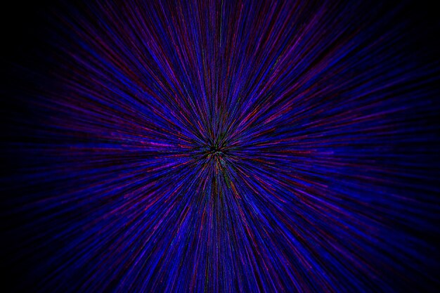 Natural lens zoom explosion radial blurred red green blue dots on black background with selective focus