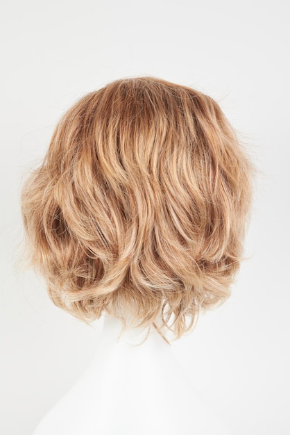 Естественно выглядящая блондинка с светлым париком на голове белого манекена Короткая стрижка на пластиковом держателе парика изолирована на белом фоне задний вид