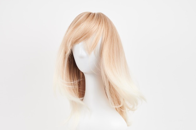 흰색 마네킹 머리에 자연스러워 보이는 금발 가발 흰색 배경에 분리된 플라스틱 가발 홀더에 긴 머리