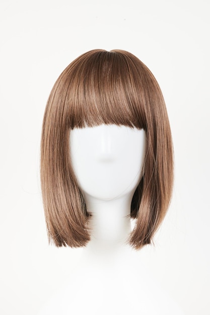 Natural looking dark brunet wig on white mannequin head Middle length brown hair on the plastic wig holder isolated on white background front view