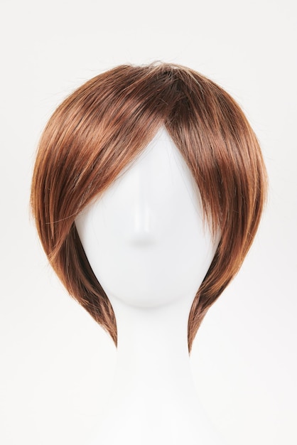 Photo natural looking dark brunet wig on white mannequin head short brown hair on the plastic wig holder isolated on white background front view