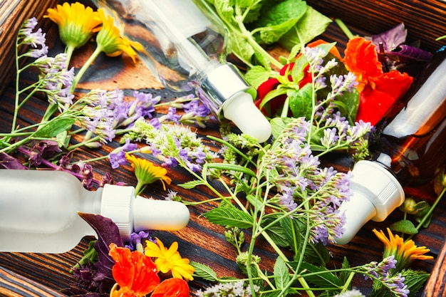 Natural medicine concept.Bottles of tincture and healthy herbs and flowers