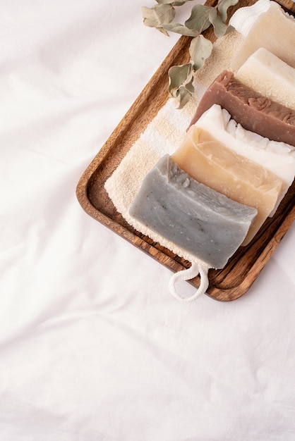 Natural organic cosmetics. Stack of hand made soap in wooden tray on white background