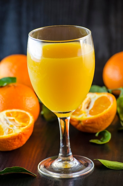 Natural organic fresh mandarin juice in a glass on a dark background