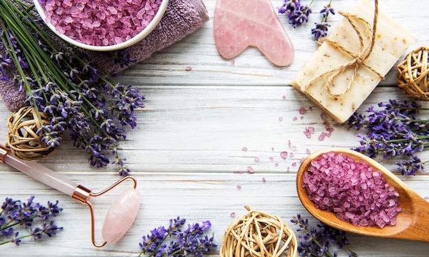 Natural organic SPA cosmetic with lavender. Flat lay bath salt, spa products and lavender flowers on wooden background. Skin care, beauty treatment concept