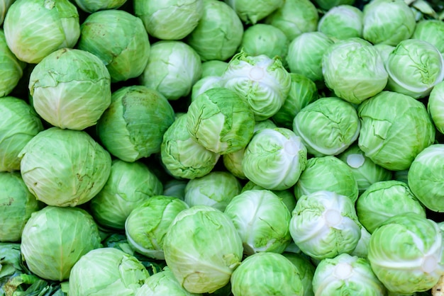 A natural pattern - fresh leafy green cabbages on the farmers' market. White cabbage as a background