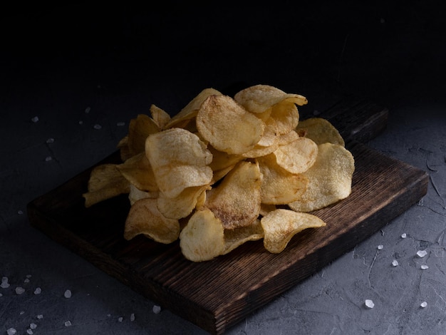 Natural potato chips on a gray concrete background