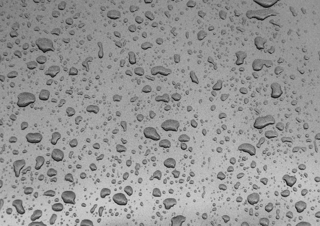 Natural raindrops texture on gray graphite car.