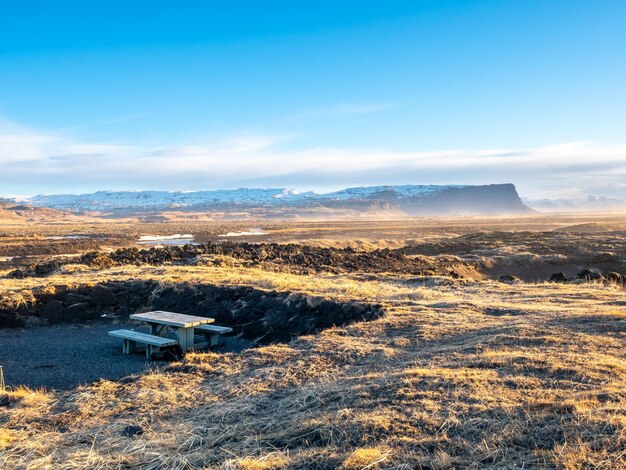 Natural scene with morning mist field mountains and cloudy blue sky in rural area in Iceland