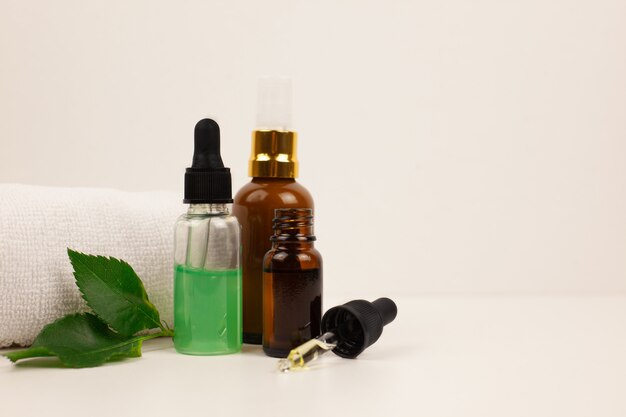 Natural skincare bottle container and organic green leaf on white background