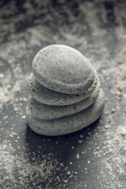 natural soap in the shape of stones stacked on top of each other on a background covered with salt