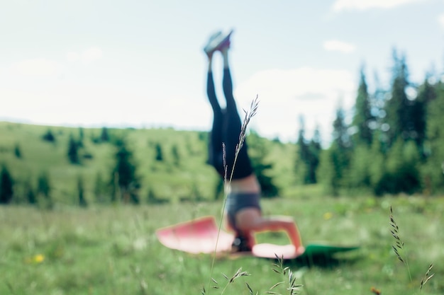 Foto naturale, sport, salute, persone, concetto di stile di vita - giovane praticante di yoga femminile indipendente in buona salute, praticando la meditazione e pone una bella vista serena della montagna che si affaccia sulla purezza