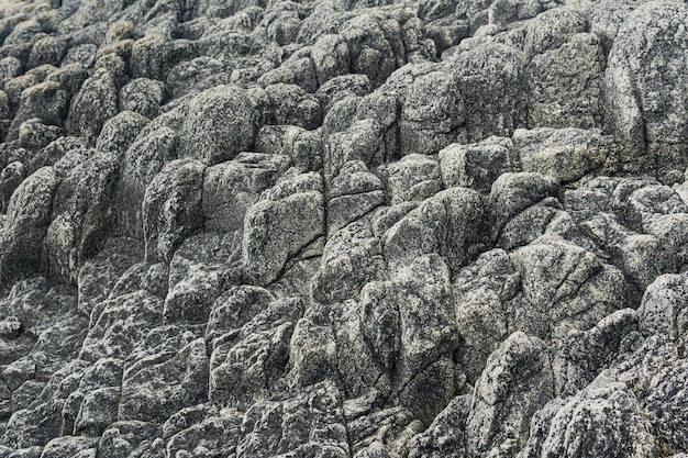 Фото Природный каменный фон остатки лавовых базальтовых колонн образуют рельефную поверхность