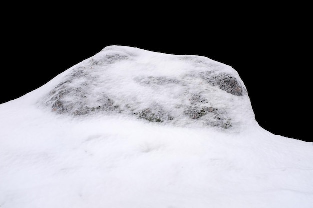 Photo natural stone in snow isolated on black background. high quality photo