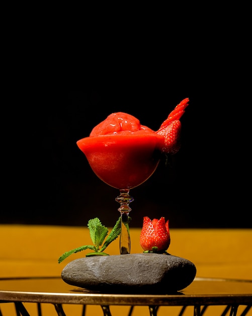 Cocktail naturale di daiquiri alla fragola con sfondo nero su un tavolo