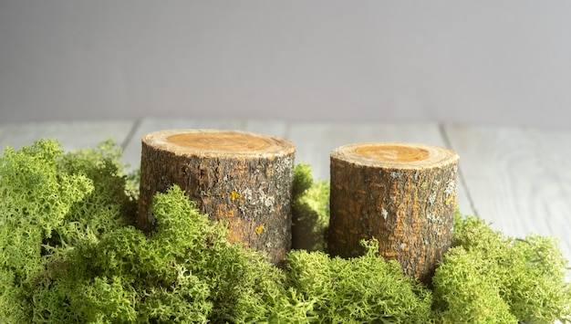 Natural style. Wooden podiums or display stands with green moss on gray table. Still life for products presentation. . 