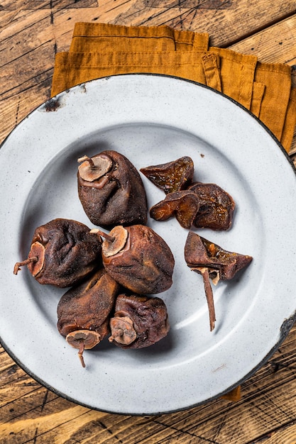 Natural Sun Dried persimmon fruit on a plate Wooden background Top view