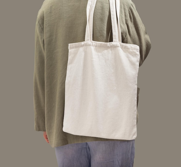 Photo natural textile eco tote bag mock up on shoulder woman back with green shopper