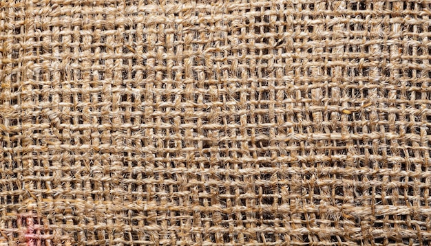 Natural textured background of intertwined threads Macro photo of the texture of old burlap Light brown abstract background