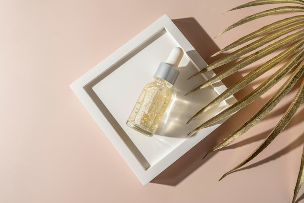 A natural transparent hyaluronic face serum or essential oil with golden parts for spa procedures lying on a white ceramic plate
