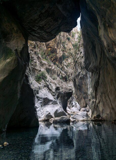 Natural tunnel in a canyon with a clean transparent river