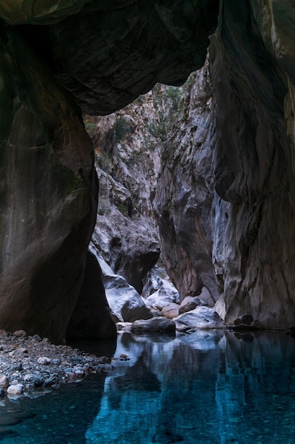 Natural tunnel in a canyon with a clean transparent river