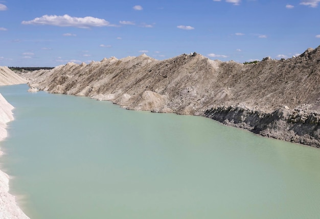 Natural water in chalk quarries against a blue sky