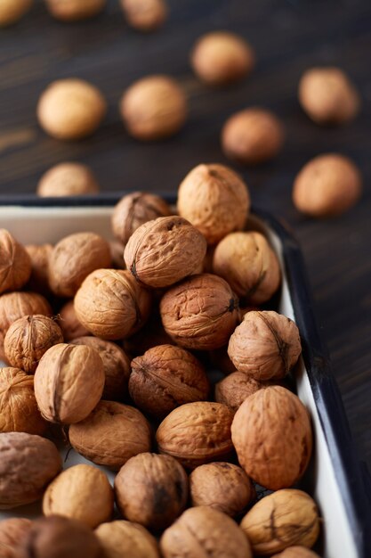 Natural whole walnuts on dark wooden table