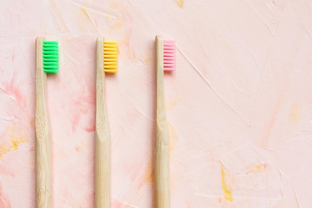 Natural wooden bamboo toothbrushes on pink