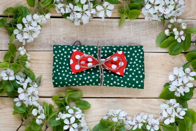 Natural wooden  with white flowers of fruit trees and green napkin with stars