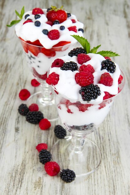 Natural yogurt with fresh berries on wooden background