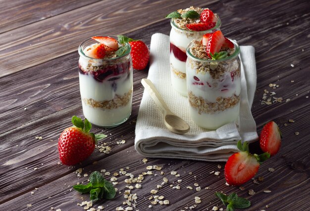 Foto yogurt naturale con marmellata, muesli e fragole fresche