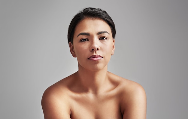 Naturally gorgeous Studio shot of a young woman with wet hair posing against a gray background