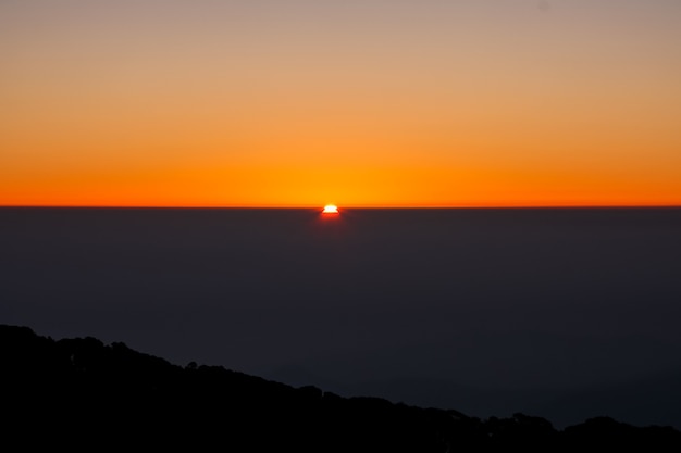 自然の背景 - オレンジ色の空を持つ山の上の日の出