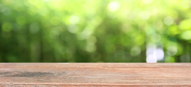 Fondo della natura, esposizione di legno della tavola sopra il giardino di verde della sfuocatura