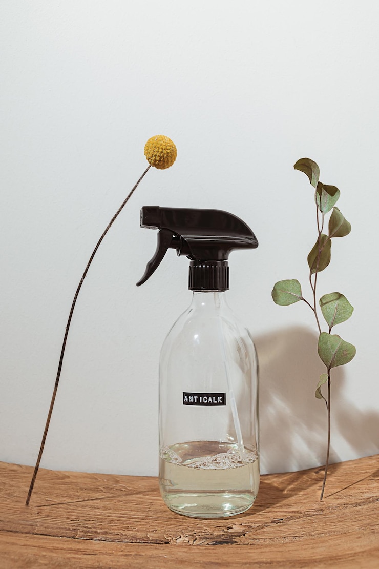 Photo ガラス洗剤ボトル、緑のユーカリの葉、バスルームの白い壁に木製の表彰台に黄色のクラスペディアボールの花を使った自然の構成。ゼロウェイスト環境にやさしいクリーニング製品。