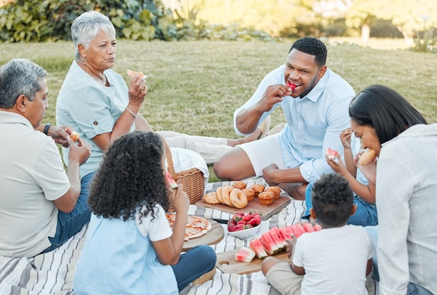 nature happy and family generations on picnic for bonding connection or love together in park smile outdoor and children eating health snacks with grandparents and parents in field for fun