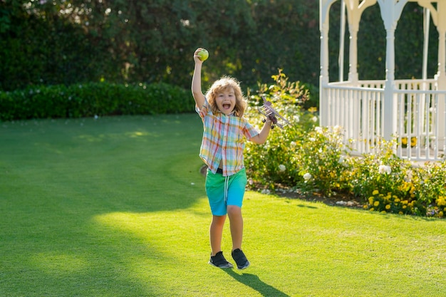 Nature and kids lifestyle Child pilot aviator with with paper wings or toy airplane dreams of traveling in summer in nature