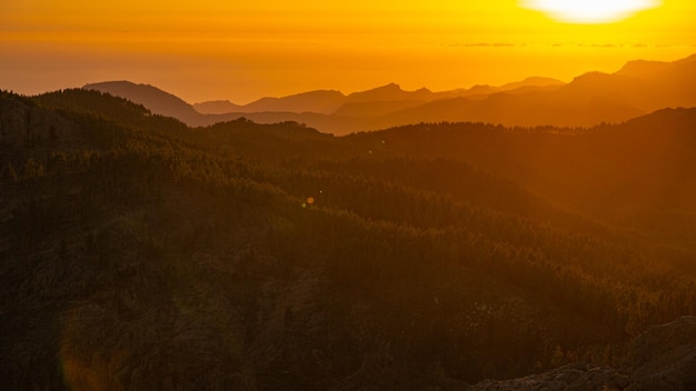 夕日とテネリフェ島の景色を望むグラン カナリア ミラドール ロケ ヌブロ山脈の自然と風景