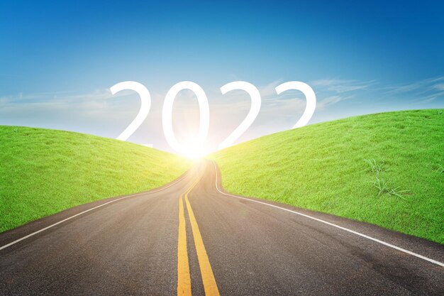 Nature landscape with asphalt road leading forward to happy new year 2022. Concept of start new year 2022.