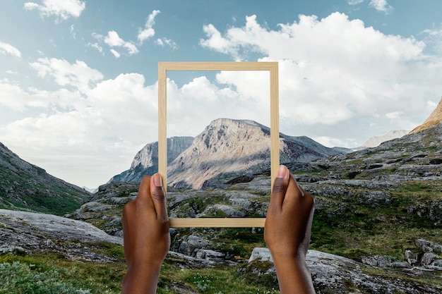 Nature landscape with hand holding frame