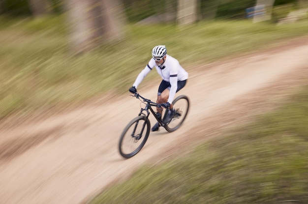 Nature mountain bike speed and sports man travel action and ride bicycle for cycling fitness or exercise Top view dirt path fast motion blur and extreme cyclist training for race on forest land