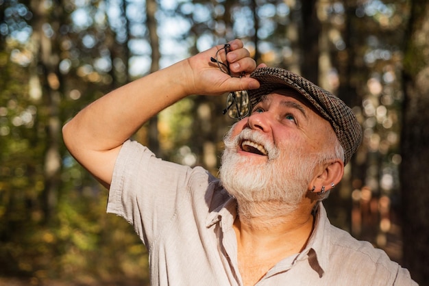 Nature observation Explore more Nature observation is relaxation Old age sight Eyesight correction Senior person with grey beard hair walk outdoors Eye care he is happy at retirement